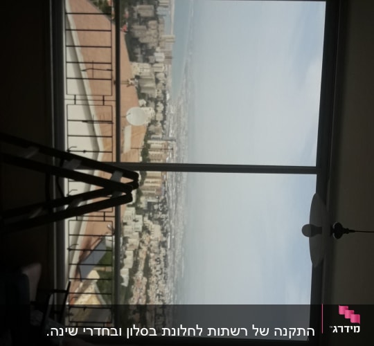 חלון עם מסגרת אלומיניום ונוף עירוני